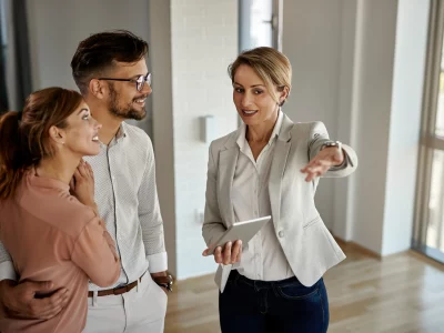 temp happy real estate agent talking couple while showing them new apartment